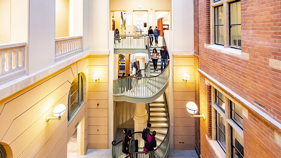 Students using the staircase in the atrium at the RCM